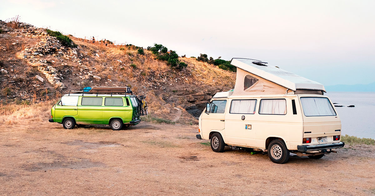 Una furgoneta camperizada y una caravana de remolque aparcadas una junto a la otra
